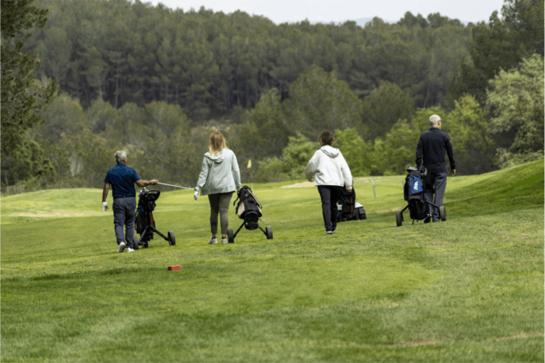 Socios de Golf con Parkinson caminan por el campo durante una jornada: ven a participar con nosotros
