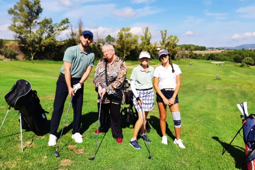 Socias y socios de Golf con Parkinson posan en el campo con sus palos