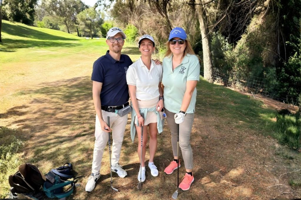 Tres jugadores de Golf con Parkinson sonríen en el campo