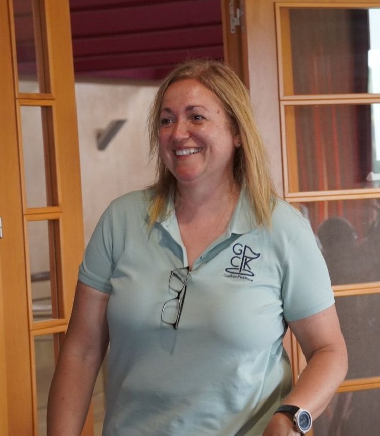 Clara, socia de Golf con Parkinson, sonríe con el polo de la asociación